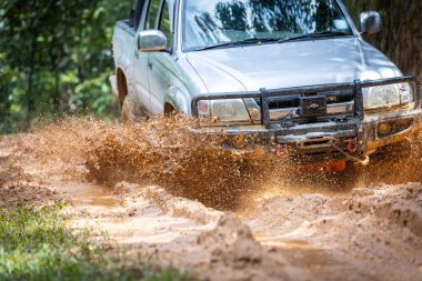 Arabalar off-road yollarında koşuyor ve doğal yollara çamur sıçrıyor. Çamurlu yolda off-road yolculuğu. Suv off road 4wd araba çamurlu su birikintisi, off-road yolu, büyük bir sıçrama ile.