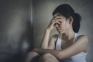 Depresyon ve endişeyle kıvranan genç bir kadın yerde oturuyor. Kadın hayal kırıklığına uğramış, kafası karışmış, mutsuz, kişisel sorunları, stresi hissediyor..