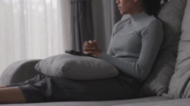 Depresyonda olan bir kadın kanepede oturur ve pencereden dışarı bakar. İlişkide Depresyon Sorununun Atmosferi, Ailede Ölüm. Stres ve aile sorunları kavramı.