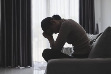 Depresyon, akıl sağlığı sorunu. Kanepede oturan Asyalı genç kadın depresyonda. Kadınlar stresli ve depresif..