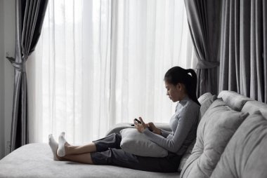 Depresyon, akıl sağlığı sorunu. Kanepede oturan Asyalı genç kadın depresyonda. Kadınlar stresli ve depresif..