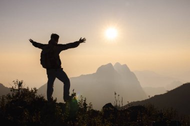İnsanoğlu dağın tepesinde ve günbatımında elini kaldırır, Özgürlük ve seyahat macerası konsepti. Dini inançlar, alanı kopyala.