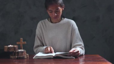 Sabahları kutsal İncil 'in üzerinde dua eden bir kadın. İnancı ve umudu olan Hristiyan kadın, Tanrı 'ya ve dinini somutlaştıran İsa Mesih' e dua etmek için elini kaldırır. Kadın, el, inanç, dua et.