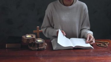 Sabahları kutsal İncil 'in üzerinde dua eden bir kadın. İnancı ve umudu olan Hristiyan kadın, Tanrı 'ya ve dinini somutlaştıran İsa Mesih' e dua etmek için elini kaldırır. Kadın, el, inanç, dua et.