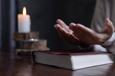Eller kadın İncil ve çapraz, dua sabah kadın ile dua tutarak dua birlikte gündoğumu arka plan üzerinde.