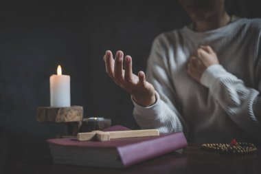 Eller kadın İncil ve çapraz, dua sabah kadın ile dua tutarak dua birlikte gündoğumu arka plan üzerinde.
