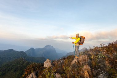 Dağların tepesinde yürüyüş yapan bir adam.