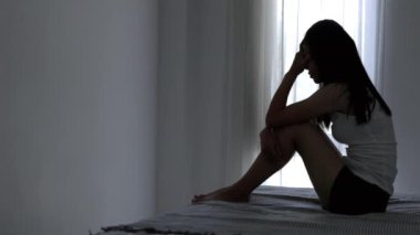 Evde depresyondan muzdarip bir insanın silueti koltukta yalnız başına oturan depresyonlu bir kadın karanlık odada üzgün ve endişeli hissediyor. İnsan streslidir..