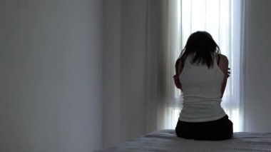 Stresli ve depresyondan muzdarip bir kadının silueti. Endişeli genç kadın umutsuzluk ve stres. Yalnız ve mutsuz kadınlar sosyal kurbanlardır. Evde yalnızlık gençliği.