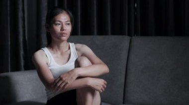 Depresyonda olan bir kadın yatak odasında oturur ve pencereden dışarı bakar. İlişkide Depresyon Sorununun Atmosferi, Ailede Ölüm. Stres ve aile sorunları kavramı.