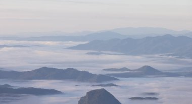 Sabah büyük dağlı sis. Tepesindeki dağda güzel bir sis denizi, Dağ Sırasının Gündoğumu Sahnesi ve Sis. 