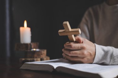 Tanrı 'ya dua ederken haç tutan Hristiyan bir kadının elleri. Dini inançlar, uzayı kopyala..