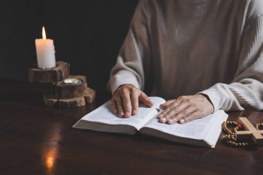 Hristiyanlık dini için dua eden sıradan bir kadın, İncil 'i inançla okumak için elleriyle dua eder..