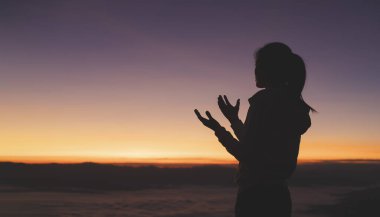 Sabah tanrıya dua eden dindar genç bir kadının silueti, ruhanilik ve din, Hıristiyanlar ve İncil okuma kavramı.