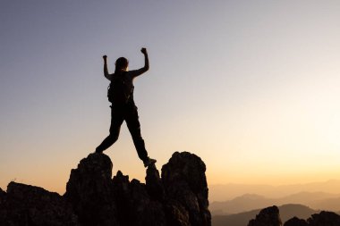 Kadın tırmanışçı başarı silueti dağlarda, başarı ilhamı, motivasyon kavramı ve hedef başarısı..
