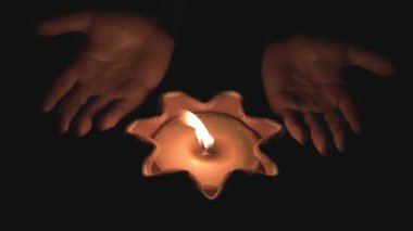 Ellere güven. Karanlığın içinde yanan bir mumu tutan eller. Tanrıya dua et, gece arkaplanı..