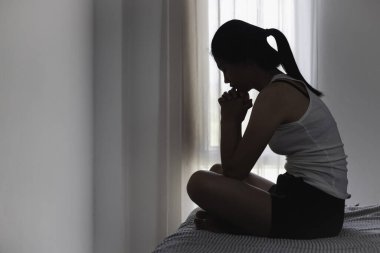Asian woman sitting on the house area Feeling sad, tired and worried about depression, mental health problems and heartbreaking concept.