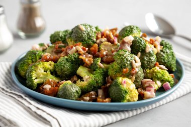 Ev yapımı Brokoli Bacon Salatası gri arka planda, yan manzaralı bir tabakta. Yakın plan..