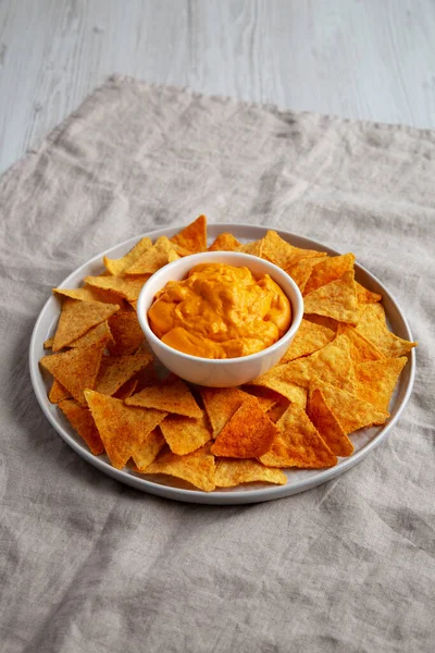 Cheese dip with tortilla chips, side view.
