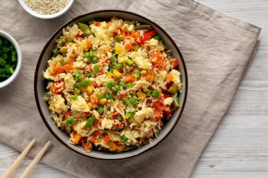 Ev yapımı Karnabahar Kızarmış Pirinç, Chives ve Susam Tohumları bir kâsede, üst manzara. Dümdüz, tepeden, yukarıdan. Metin için boşluk.