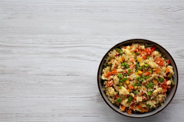 Ev yapımı Karnabahar Kızarmış Pirinç, Chives ve Susam Tohumları bir kâsede, üst manzara. Dümdüz, tepeden, yukarıdan. Metin için boşluk.