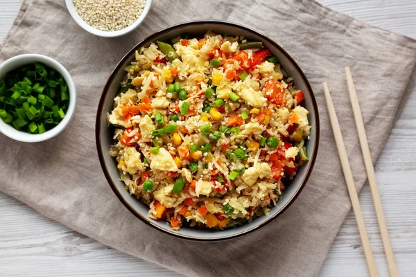 Ev yapımı Karnabahar Kızarmış Pirinç, Chives ve Susam Tohumları bir kâsede, üst manzara. Dümdüz, tepeden, yukarıdan.