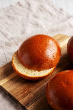 Tahta üzerinde ev yapımı Brioche Hamburger Çörekleri, alçak açılı. Boşluğu kopyala.