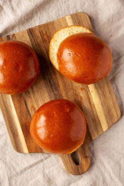 Tahta üzerinde ev yapımı Brioche Hamburger Çörekleri, üst manzara. Dümdüz, tepeden, yukarıdan. 