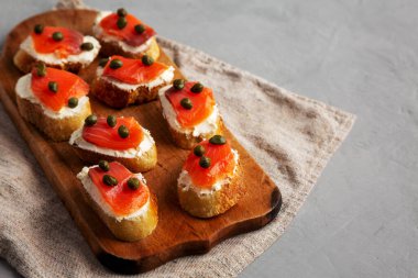 Tahta üzerinde ev yapımı füme ve krem peynirli crostini, yan manzara. Boşluğu kopyala.