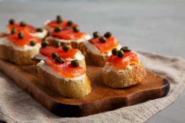 Tahta üzerinde ev yapımı füme ve krem peynirli crostini, yan manzara. Yakın plan..