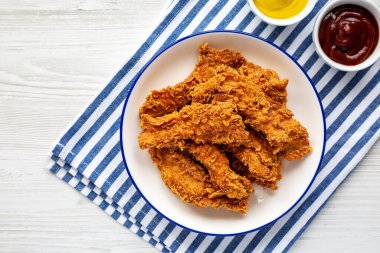 Hardallı ev yapımı tavuk şeritleri ve bir tabakta barbekü, üst manzara. Dümdüz, tepeden, yukarıdan. Metin için boşluk.