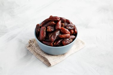 Bowl 'daki Pitted Organik Tarihler, gri arka plan, kenar görünüm.