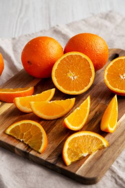 Beyaz ahşap arka planda çiğ organik portakal meyvesi, düşük açılı görünüm.