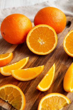 Beyaz ahşap arka planda çiğ organik portakal meyvesi, kenar görünüm.