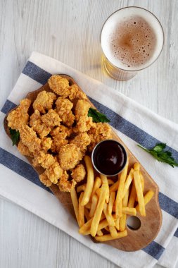 Homemade Popcorn Chicken with BBQ Sauce on a Rustic Wooden Board, top view. Flat lay, overhead, from above. 