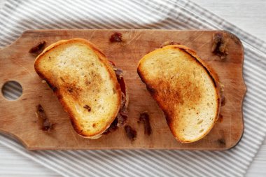 Homemade British Bacon Sandwich on a rustic wooden board, top view. Flat lay, overhead, from above.