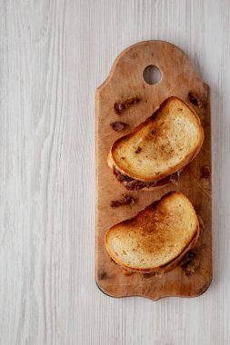 Homemade British Bacon Sandwich on a rustic wooden board, top view. Flat lay, overhead, from above. Copy space.