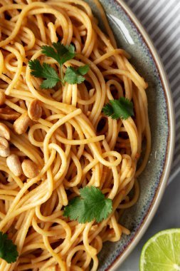 Homemade Asian Peanut Sauce Noodles on a Plate, top view. Flat lay, overhead, from above. Close-up.