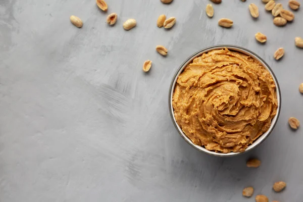 Yummy Organic Peanut Butter in a Bowl, top view. Flat lay, overhead, from above. Space for text.
