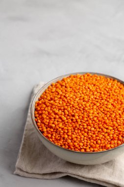 Red Lentils Legume in a Bowl on a gray background, side view. 