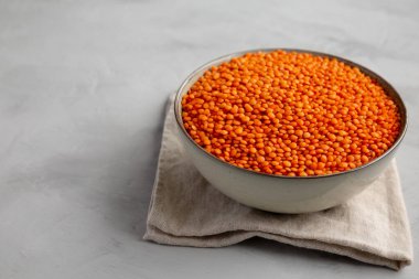 Red Lentils Legume in a Bowl on a gray background, side view. Copy space.