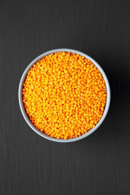 Red Lentils Legume in a Bowl on a black background, top view. Flat lay, overhead, from above. 