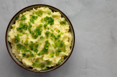 Homemade Mashed Potatoes with Chives in a Bowl, top view. Flat lay, overhead, from above. Space for text.