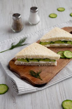 Homemade English Cucumber Sandwiches on a rustic wooden board, side view. 