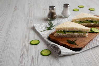 Homemade English Cucumber Sandwiches on a rustic wooden board, side view. Space for text.
