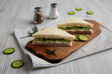 Homemade English Cucumber Sandwiches on a rustic wooden board, side view. 