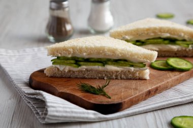 Homemade English Cucumber Sandwiches on a rustic wooden board, side view. 