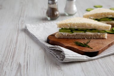 Homemade English Cucumber Sandwiches on a rustic wooden board, side view. Copy space.