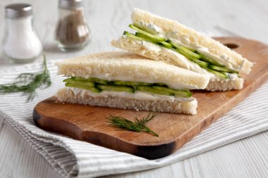 Homemade English Cucumber Sandwiches on a rustic wooden board, side view. Close-up.