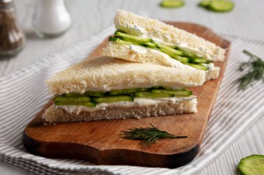 Homemade English Cucumber Sandwiches on a rustic wooden board, side view. Close-up.
